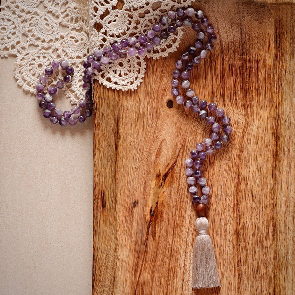 Intuition Mala Beads. Hand-knotted with beautiful, untreated, high-grade Amethyst beads, featuring a wooden guru bead and handmade cotton tassel.